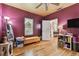 Vibrant bedroom with hardwood floors, natural light, and a stylish yellow bench at 125 E Grant St, Orlando, FL 32806