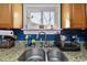 Kitchen sink with granite countertop and wood cabinetry at 125 E Grant St, Orlando, FL 32806