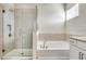 Bathroom featuring glass shower, tile walls, and a soaking tub under a window at 16207 Point Rock Dr, Winter Garden, FL 34787