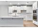 Bright kitchen featuring white cabinets, a center island with breakfast bar, and stainless steel appliances at 16207 Point Rock Dr, Winter Garden, FL 34787