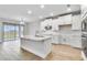 Open-concept kitchen with large island, white cabinetry, stainless steel appliances, and access to the backyard at 16207 Point Rock Dr, Winter Garden, FL 34787