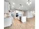 Open-concept kitchen with stainless steel appliances, white cabinets, tiled floor and kitchen island with sink at 16207 Point Rock Dr, Winter Garden, FL 34787