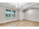 Bright and airy living room with decorative tray ceiling, two windows, and light wood-look tile flooring at 16207 Point Rock Dr, Winter Garden, FL 34787