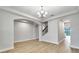 Spacious living room with arched doorways, tray ceilings, chandelier, and hard surface flooring throughout at 16207 Point Rock Dr, Winter Garden, FL 34787
