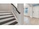 Elegant staircase with iron spindles and wood treads leading to a bright, open living space with tile flooring at 16207 Point Rock Dr, Winter Garden, FL 34787