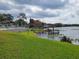 Lakeside view featuring a gazebo on a wooden dock and a green lawn at 169 Fallwood St, Fern Park, FL 32730