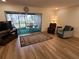 Bright living room with sliding glass doors to the lanai, wood floors, and comfortable seating area at 169 Fallwood St, Fern Park, FL 32730