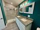 Bathroom featuring a double vanity with granite countertop, tile floors, a walk-in shower, and modern lighting at 171 Church St, Geneva, FL 32732