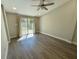 Bedroom with light-colored walls, wood-look floors, ceiling fan, and sliding glass doors to the yard at 171 Church St, Geneva, FL 32732