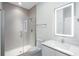 Modern bathroom featuring a glass shower, tiled walls, and a vanity with a lighted mirror at 17442 Hidden Forest Dr, Clermont, FL 34714
