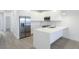 Modern kitchen featuring stainless appliances, sleek white cabinets, a breakfast bar and light wood flooring at 17442 Hidden Forest Dr, Clermont, FL 34714