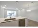 Bright open concept kitchen featuring a stainless dishwasher, double sink and sliding glass doors at 17442 Hidden Forest Dr, Clermont, FL 34714