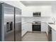 Modern kitchen features stainless steel appliances, sleek white cabinets, and hardwood floors at 17442 Hidden Forest Dr, Clermont, FL 34714