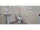 A half bathroom with a pedestal sink, a standard toilet, and tile flooring at 18046 Cider Mill Ln, Winter Garden, FL 34787