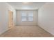 A bright, carpeted bedroom features two windows with blinds and neutral wall paint at 18046 Cider Mill Ln, Winter Garden, FL 34787