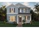 Charming two-story home with a covered porch, a well-manicured lawn and lush tropical landscaping at 18046 Cider Mill Ln, Winter Garden, FL 34787
