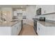 Modern kitchen with white cabinets, stainless steel appliances, granite countertops, and tile flooring at 18046 Cider Mill Ln, Winter Garden, FL 34787