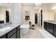 Elegant bathroom featuring a freestanding tub, black vanities, decorative wall art, and pendant lighting at 18405 Mowry Ct, Orlando, FL 32827