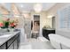 Bright bathroom with a glass shower, vanity with granite countertop, tub, and decorative chandelier lighting at 18405 Mowry Ct, Orlando, FL 32827