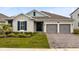 Charming home with a well-manicured lawn and a two-car garage with a brick paved driveway at 18405 Mowry Ct, Orlando, FL 32827