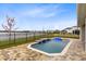 Backyard pool overlooking a lake with waterfall features, blue lounge chairs and fence at 18405 Mowry Ct, Orlando, FL 32827