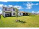 Charming two-story home featuring a spacious backyard with lush green grass and a cozy covered patio at 1972 Spring Shower Cir, Kissimmee, FL 34744