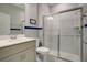 Bathroom featuring a glass-enclosed shower, neutral cabinets, modern sink, and a matching blue accent stripe at 1972 Spring Shower Cir, Kissimmee, FL 34744