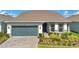 Charming single-story home featuring a two-car garage, well-manicured lawn, and stone accents at 1972 Spring Shower Cir, Kissimmee, FL 34744
