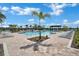 Stunning community pool area featuring ample lounge seating, palm trees, and a pergola for shade at 1972 Spring Shower Cir, Kissimmee, FL 34744