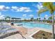 Resort-style community pool with comfortable lounge chairs, swaying palm trees, and a relaxing pergola at 1972 Spring Shower Cir, Kissimmee, FL 34744