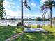 Lush green backyard with a seating area and direct access to the serene lake at 234 N Griffin Dr, Casselberry, FL 32707