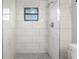 Modern bathroom shower with white marble tiles and a window at 2531 Ludlow St, Deltona, FL 32738