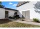 Exterior side entrance featuring gray barn doors and nicely landscaped flower beds at 2531 Ludlow St, Deltona, FL 32738