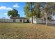 Exterior showcasing a well-maintained yard, fenced perimeter, and mature trees enhancing the home's curb appeal at 2531 Ludlow St, Deltona, FL 32738