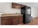 Kitchenette with dark cabinets, granite countertop and a modern black refrigerator at 2531 Ludlow St, Deltona, FL 32738