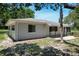 A single story home with a gray exterior, surrounded by green lawns and landscaping at 265 W Constance Rd, Debary, FL 32713