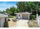 Detached one car garage with gray siding and a brick lined path to the back yard at 265 W Constance Rd, Debary, FL 32713