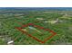 Aerial view of a beautiful property surrounded by dense trees, with the lot lines highlighted in red at 2650 Howard Ave, Oviedo, FL 32765