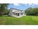 This backyard features a large lawn and a white house with a covered patio at 2650 Howard Ave, Oviedo, FL 32765