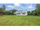 This backyard features a large lawn and a white house with a covered patio at 2650 Howard Ave, Oviedo, FL 32765