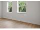 Bright bedroom featuring hardwood floors, base trim, and natural light from two windows at 2650 Howard Ave, Oviedo, FL 32765