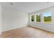 Bright bedroom with hardwood floors and abundant natural light from three large windows at 2650 Howard Ave, Oviedo, FL 32765
