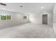 Open room with new carpet and bright windows with views of surrounding trees and lush foliage at 2650 Howard Ave, Oviedo, FL 32765