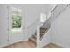 Bright entryway featuring hardwood floors, staircase with black metal railings and glass front door at 2650 Howard Ave, Oviedo, FL 32765