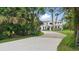 An exterior side view of the house showcasing the stone facade, white paneling, and a gravel driveway at 2650 Howard Ave, Oviedo, FL 32765