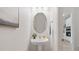 Half-bath featuring a pedestal sink, oval mirror, and a view of the kitchen through an open doorway at 2650 Howard Ave, Oviedo, FL 32765