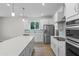 Open kitchen featuring a center island, stainless appliances, pendant lighting, and custom cabinetry at 2650 Howard Ave, Oviedo, FL 32765