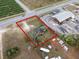 This aerial view showcases a property with a large lot and mature trees near a commercial area and roadways at 29650 State Road 19, Tavares, FL 32778