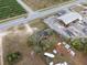 This aerial view showcases a property with a large lot and mature trees near a commercial area and roadways at 29650 State Road 19, Tavares, FL 32778