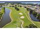 Scenic aerial view of golf course with lush green fairways, lakes, and upscale residential homes at 30215 Island Club Dr, Deer Island, FL 32778